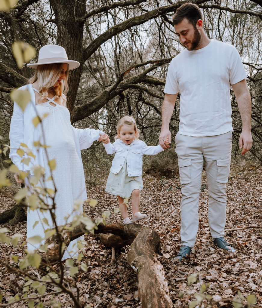 Boho maternity shoot with Mum Dad and little girl in a woodland setting.
