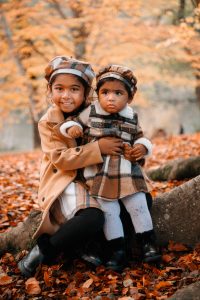 Two girls sitting on a branch. Lovely Autumnal woodland