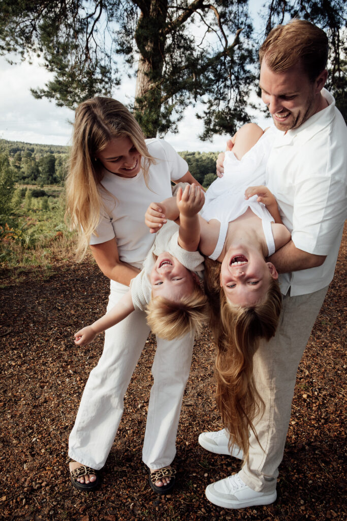 Golden hour photography of a family playing with their children - tipping them upside down