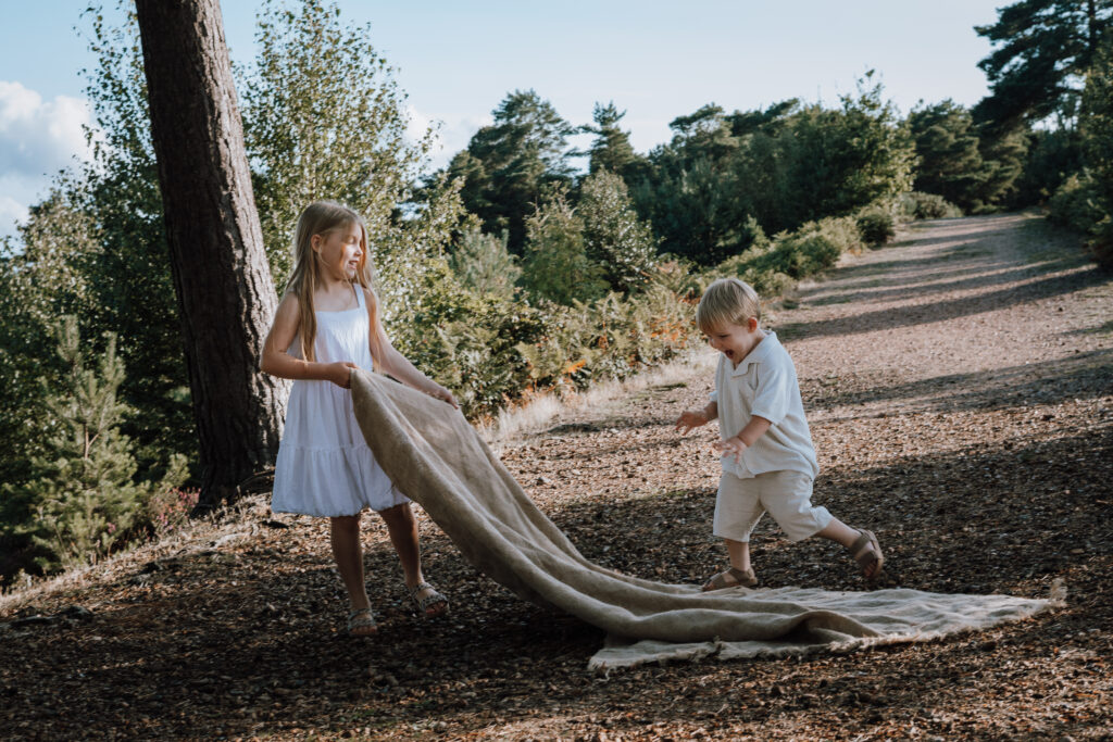 Girl and boy playing with blanket