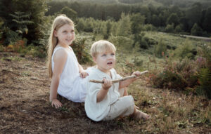 A boy and girl sitting at sunset