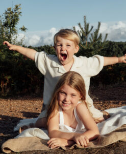 Brother sitting on top of sister having fun