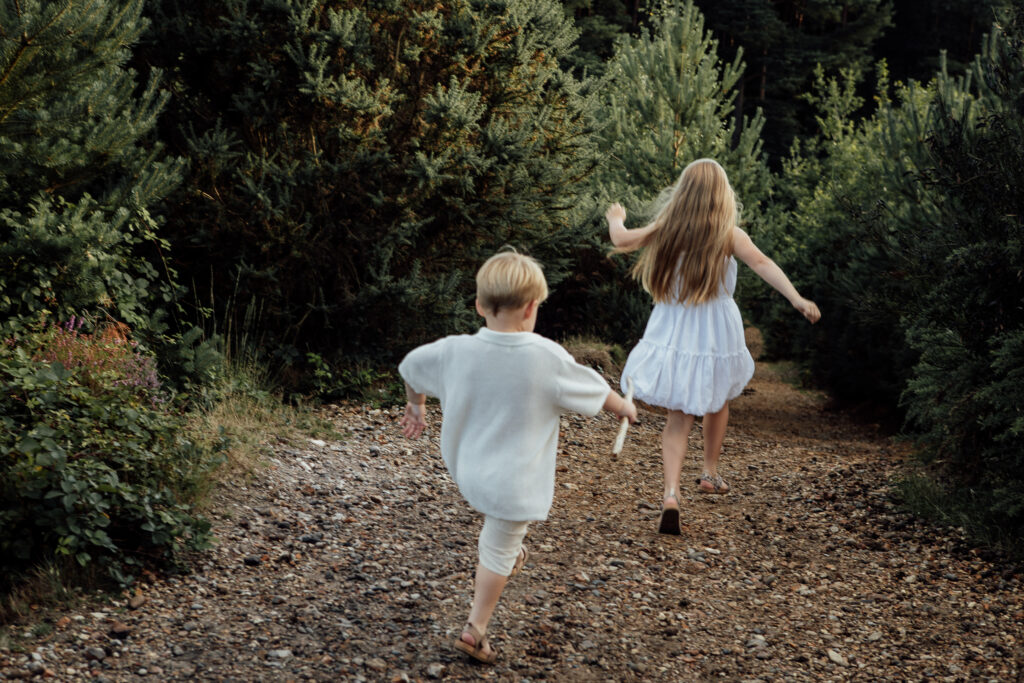 Girl and boy at the end of the photo shoot running down hill