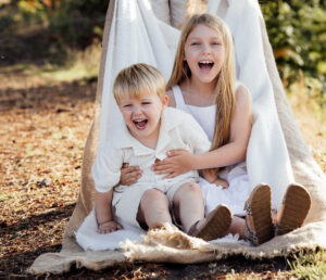 Children laughing playing on a blanket