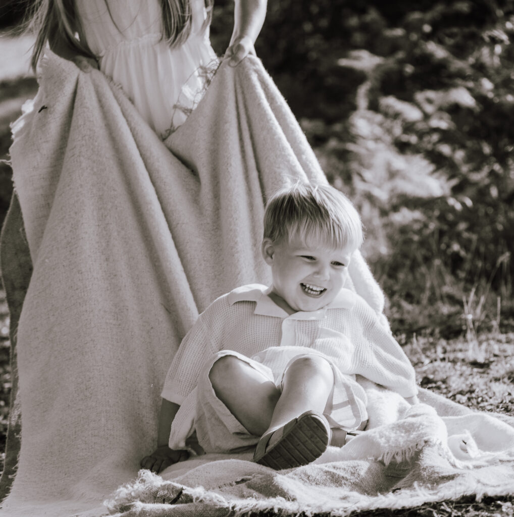 Girl dragging a boy laughing on a blanket