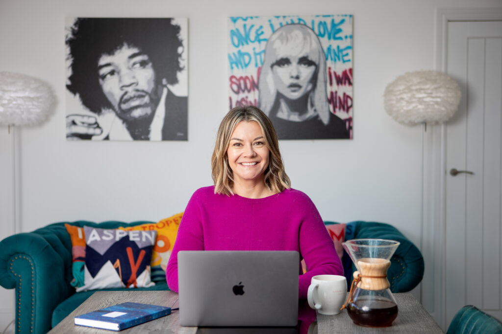Photo of Dr Gemma Roberts sitting at there desk working on her computer, she is smiling to the camera.