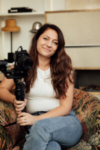 Photograph of the videographer Katy ward sitting on a armchair looking at the camera