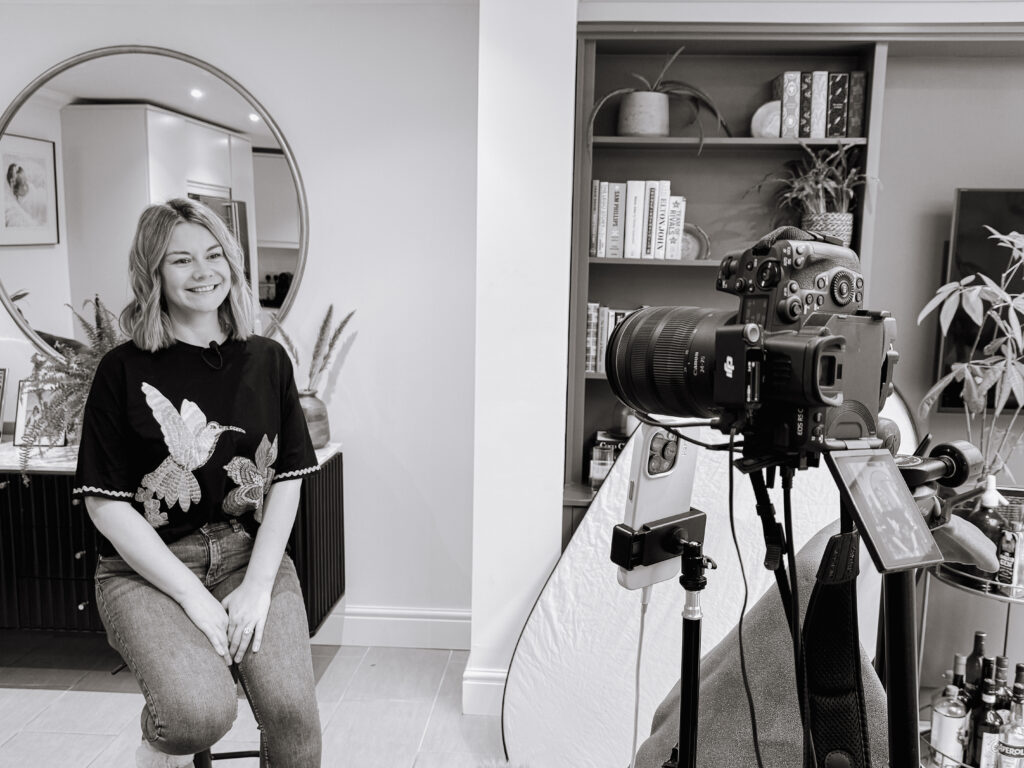 Behind the scenes black and white image of Dr Gemma Roberts being filmed.