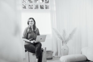 Image of a lady looking away from the camera smiling.  The image is in black and white
