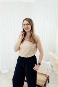Headshot of a woman on her phone taken in a studio style location.